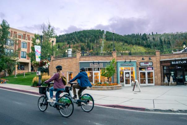 Two bikers ride up Lower Main Street on the Summit County Bike Share bikes