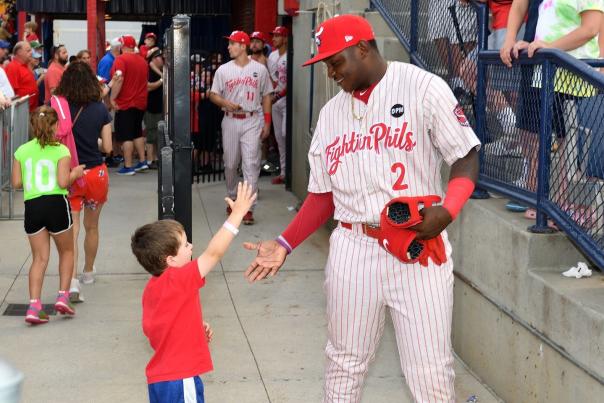 A player high-fiving a child after the baseball game.