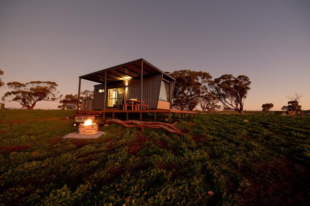 Heyscape Tiny Cabin in the middle of a field at dusk
