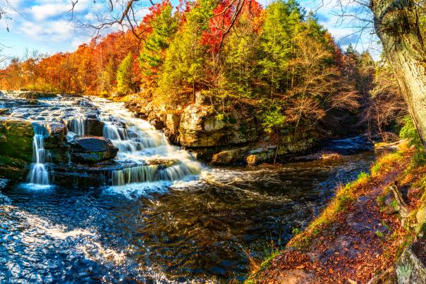 A view of Shohola Falls surrounded by autumnal trees in the Pocono Mountains.
