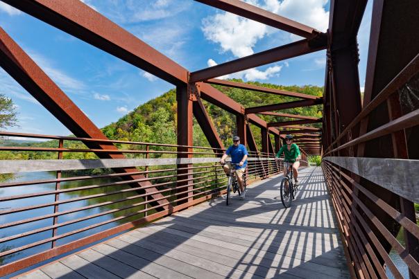 Two bikers cross the Mansion House Bridge connecting Jim Thorpe to the D&L Trail in the Poconos.