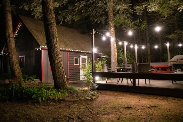 Lights glow in the night outside a charming cabin at Babbling Brook Cottages in the Poconos.