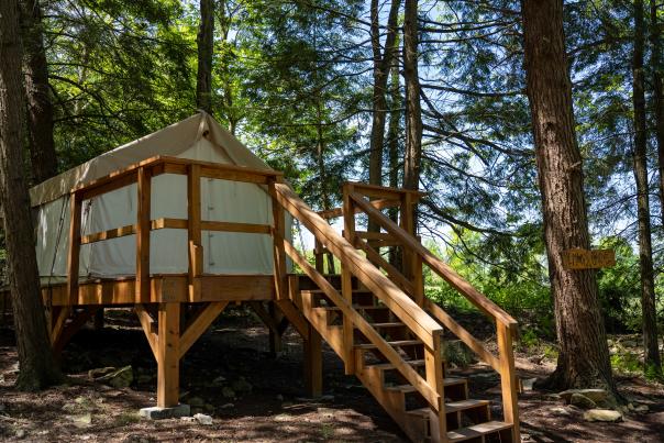 A view of a glamping tent in a forest at Blue Mountain in the Poconos.