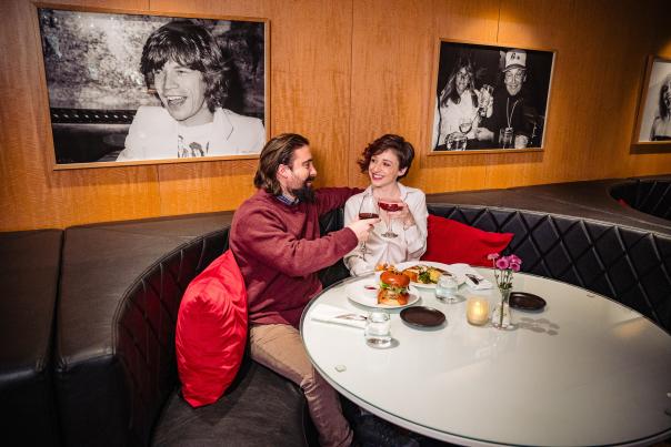 A couple raises their wine glasses in a cozy booth at Bar Louis at the Hotel Fauchere in the Pocono Mountains.