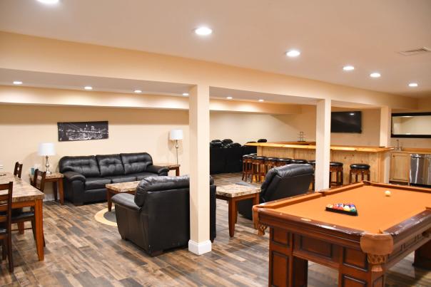 Living space with couches, pool table, a bar, table and chairs