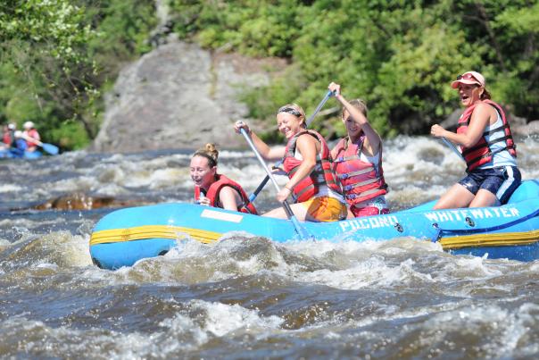 A group enjoys navigating the rapids while whitewater rafting on the Lehigh River in the Poconos.