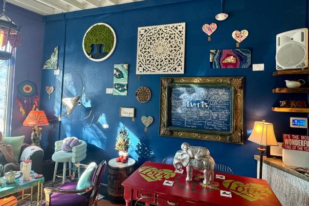 A blue wall filled with heart-art. Little price tags hang from each piece of art
