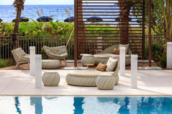 A poolside lounge area with an ocean view in Pompano Beach
