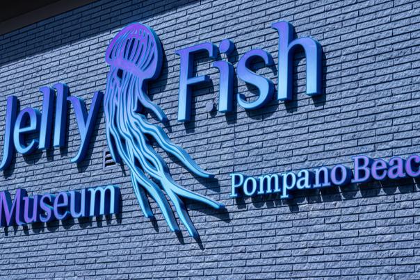 A purple and blue sign for the Jellyfish Museum in Pompano Beach.