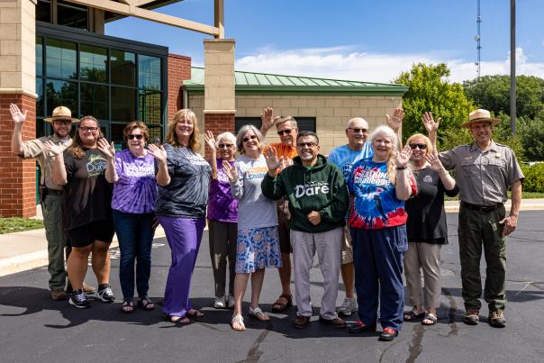 A group of people wave at the camera