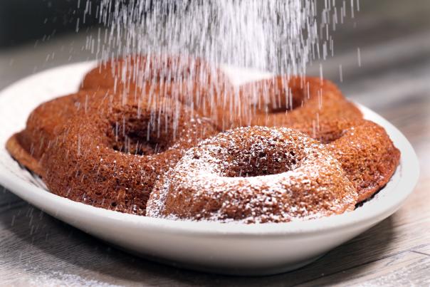 Gingerbread vegan donuts being powdered with sugar