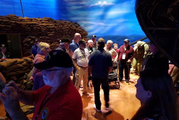A group of people walking around an exhibit at the National Museum of the Marine Corps for a reunion