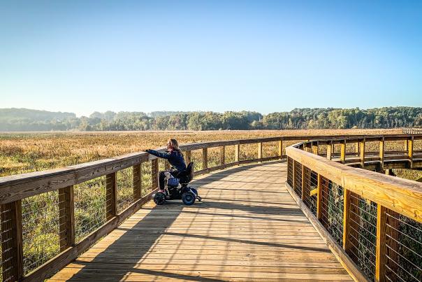 Woman in wheelchair on Neabsco Creek Boardwalk during Fall