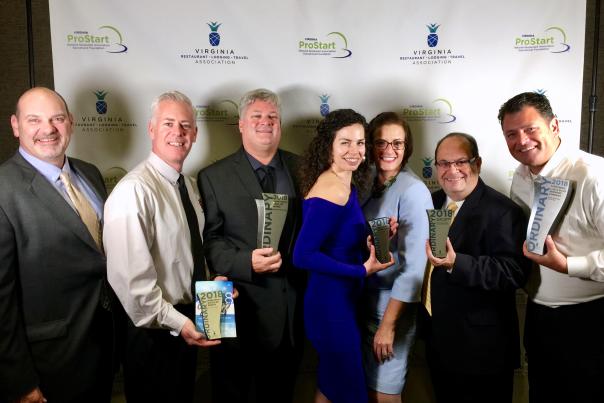 group of people standing together holding awards