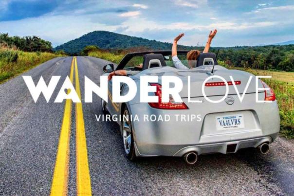 couple on a road in a convertible with hands raised in the air WanderLove logo overlayed