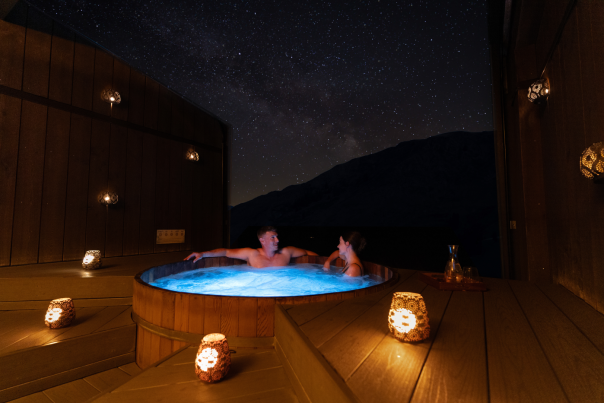 A couple enjoy a private spa at Onsen Hot Pools in Arthurs Point on a clear night