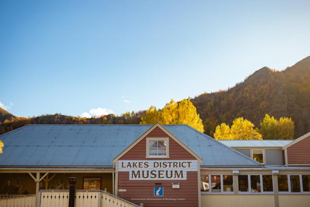 A historic building set against a backdrop of autumn colours and blue sky