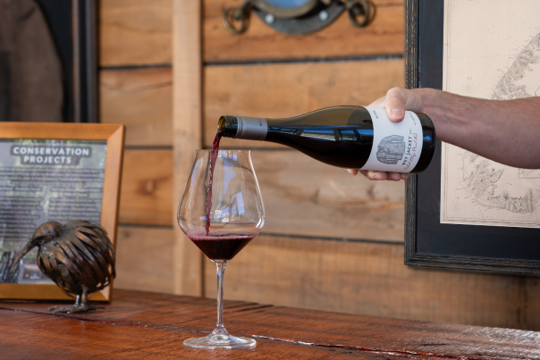 Hand pouring glass of Wet Jacket Pinot Noir