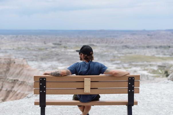 Visitor sitting on bench at one of the overlooks in Badlands National Park