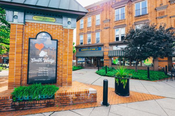 An image of a brick column featuring a black "South Wedge" sign.