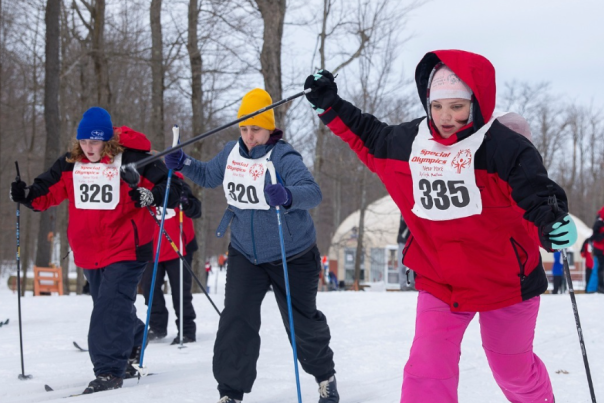 A photo of three Special Olympics athletes competing in the skiing competition
