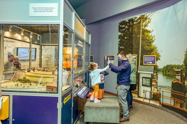 A family high fives at a Rochester Museum and Science Center Exhibit