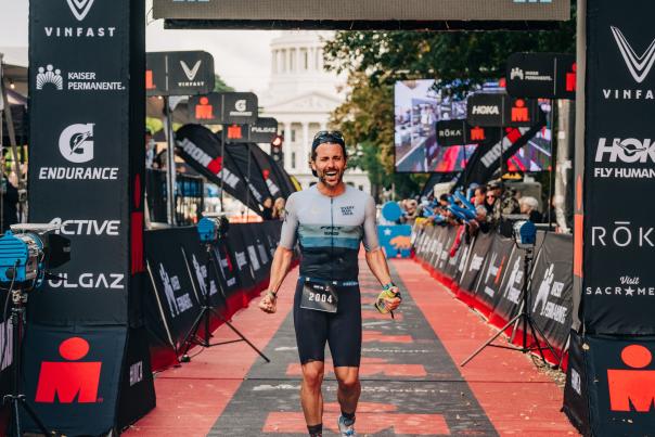 Athlete cheering while crossing the IRONMAN race finish line