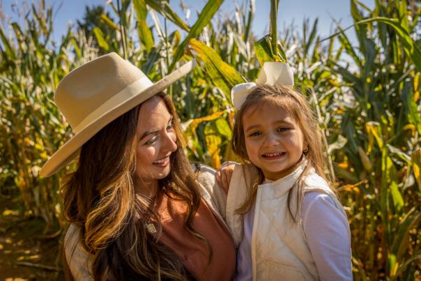 Mom holding daughter in corn maze