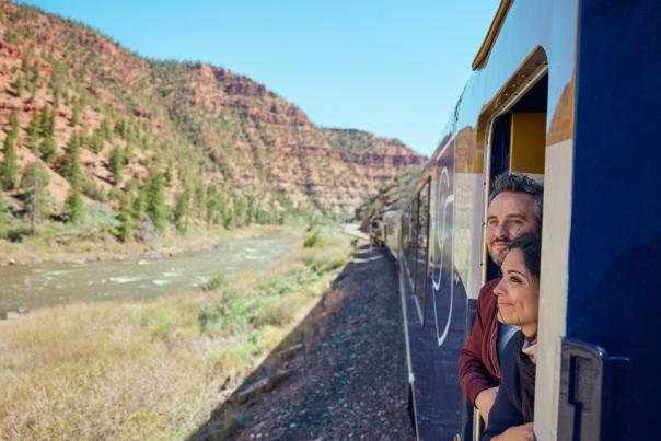 Two guests on the Canyon Spirit railway line looking out of the train in Utah.
