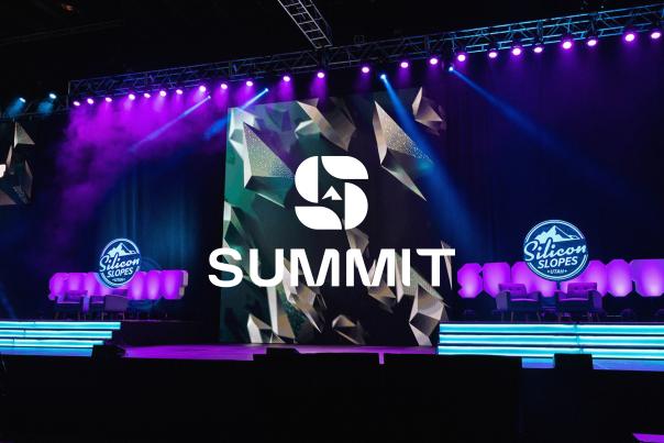 Stage setup with purple and blue lights, logos that say Silicon Slopes and a Summit Logo overlay