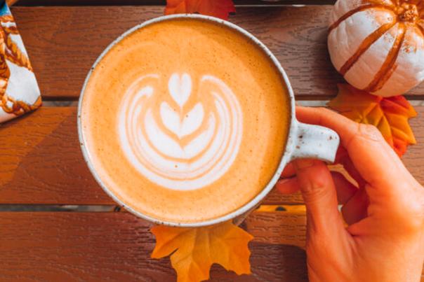 Overhead view of cup of coffee with fall leaves