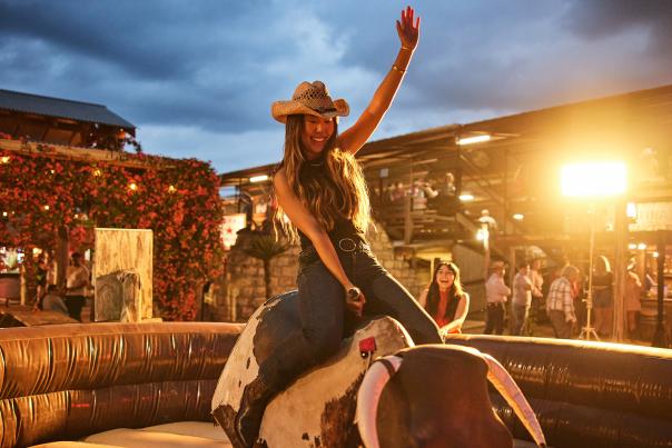 Girl on mechanical bull at Tejas Rodeo