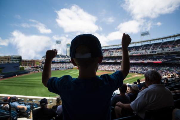 A stock image of a child cheering on a professional baseball game.