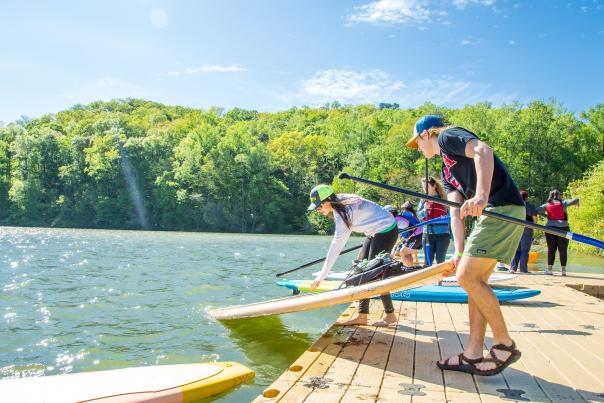 People on the dock at Morgan Falls Overlook park putting paddleboards into the river.