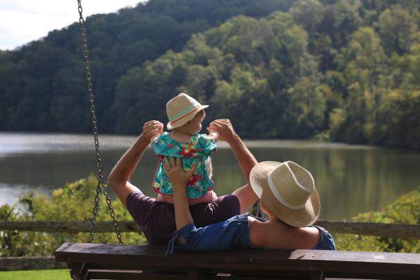 Vagabond 3 World Travel Blogger sitting with husband and toddler looking over the Bull Sluice Lake at Morgan Falls Park in Sandy Springs, GA