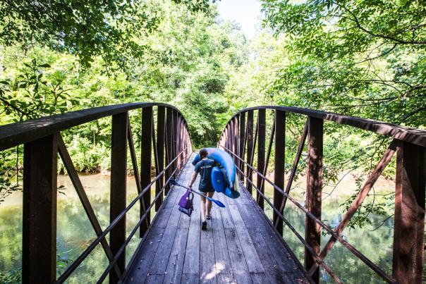 Woman walking across the bridge at the Powers Island Unit of the Chattahoochee River National Recreation Area