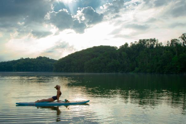 A woman doing stand up paddleboard yoga