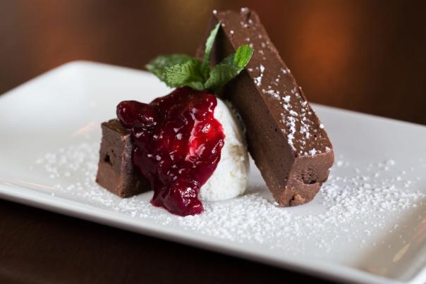 Chocolate cake with vanilla and a cherry sauce.