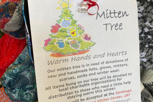 Tree of hats and mittens with Mitten Tree sign and description