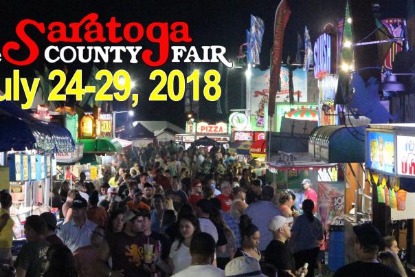 The crowd at night at the Saratoga Co. Fair with the logo and dates