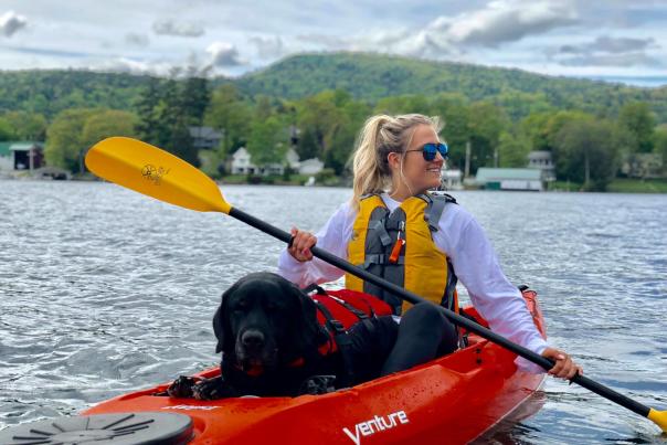 Woman and dog kayaking through lake george