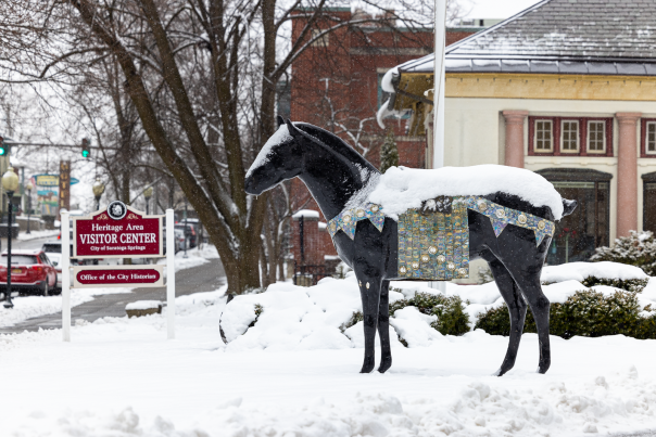 saratoga visitor center in winter with snow on horse statue