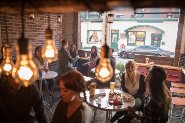 Group of people dining at Henry Street Taproom in Saratoga Springs with focus on lightbulbs