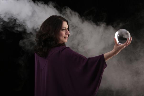 woman with purple cap and crystal ball in hand