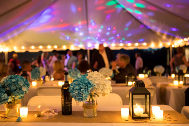 Swedish Hill Farm Evening wedding reception under lit tent with flowers and lanterns