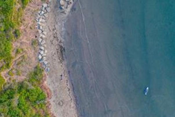 Aerial view of secluded beach in Scarborough with boat moored off the shore