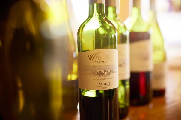 green wine bottles on wood counter