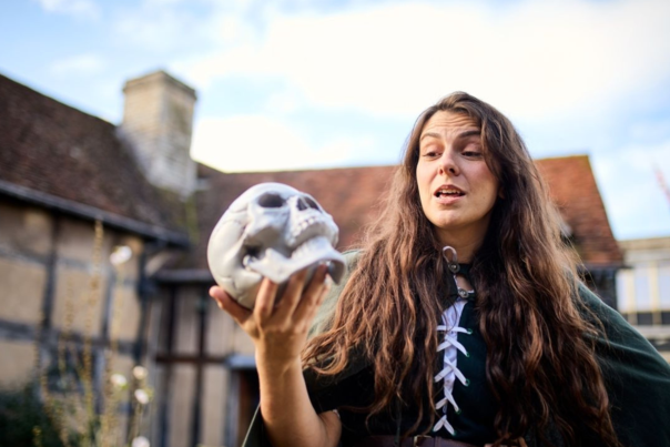 A woman holding a skull outside of Shakespeare's Birthplace