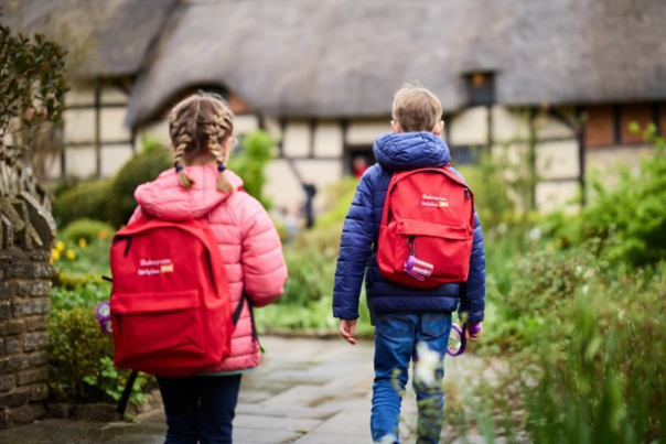 A girl and a boy wearing red backpacks at Anne Hathaway's Cottage