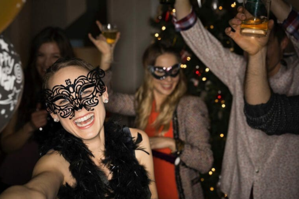 A group of women wearing masquerade masks celebrating NYE